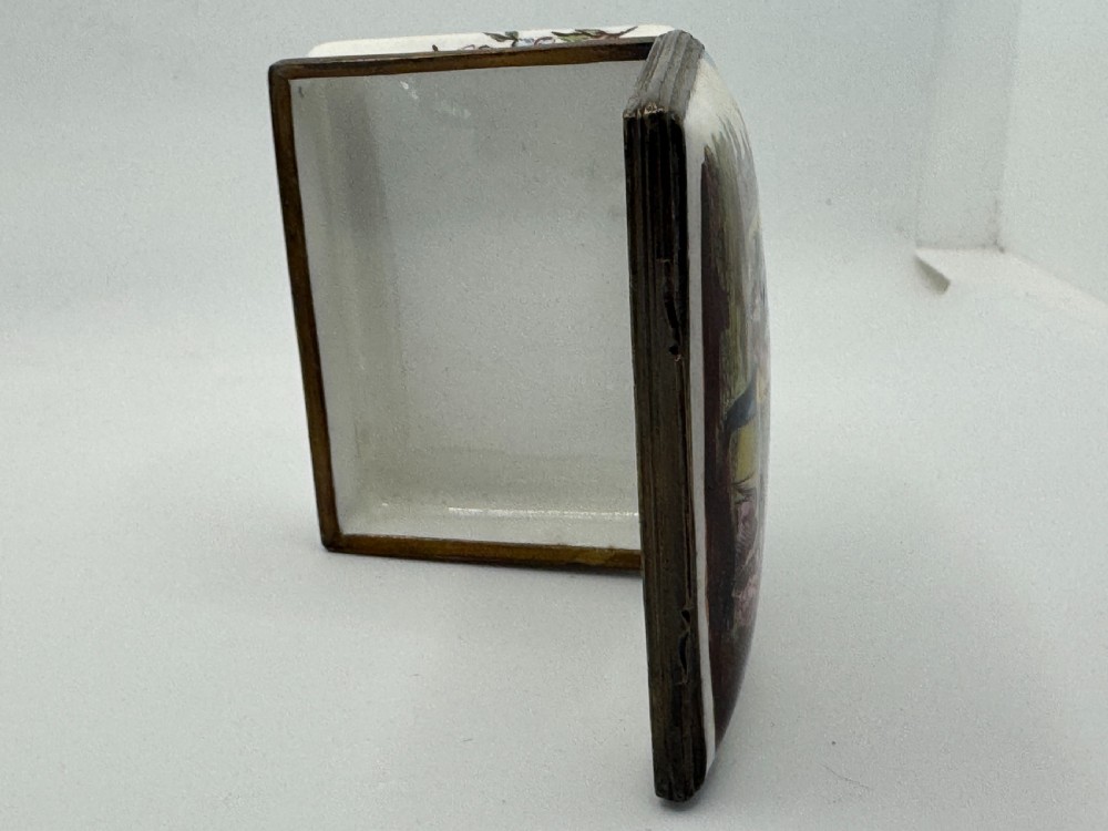 A rectangular 18th-century Bilston enamel box decorated with a painted pastoral scene on the lid and floral sprigs along the white base. View XVI