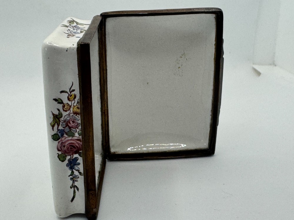 A rectangular 18th-century Bilston enamel box decorated with a painted pastoral scene on the lid and floral sprigs along the white base. View XVII