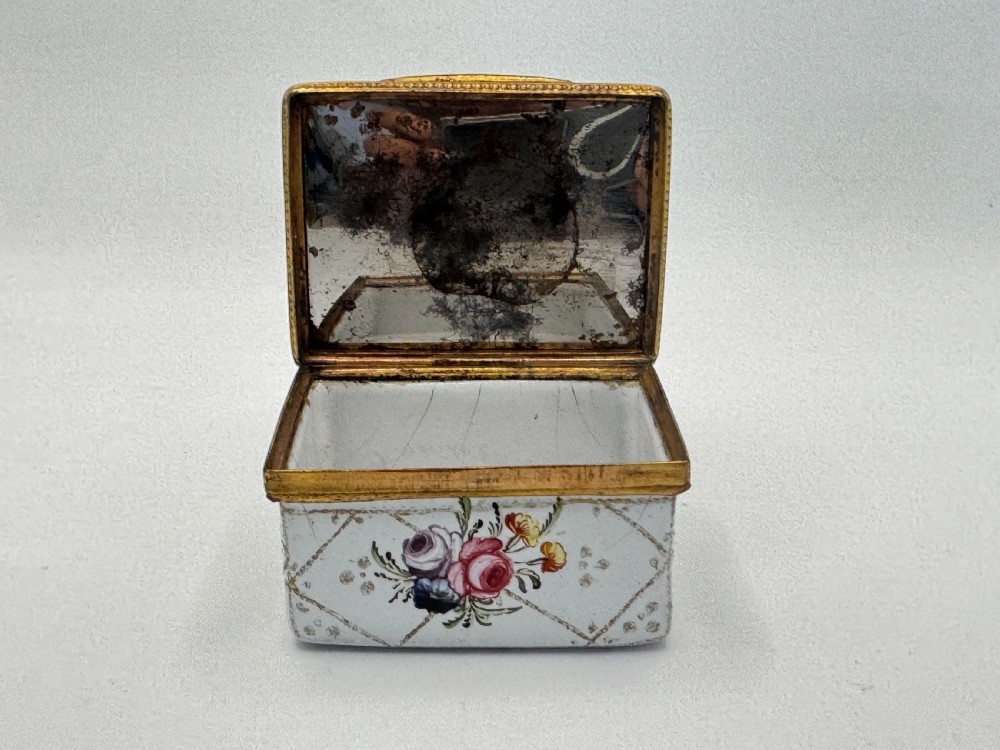 A small 19th-century rectangular enamel box decorated with a hand-painted pastoral scene surrounded by gilt scrollwork. View VI