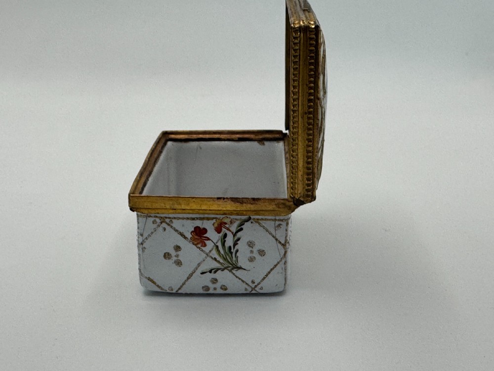 A small 19th-century rectangular enamel box decorated with a hand-painted pastoral scene surrounded by gilt scrollwork. View VIII