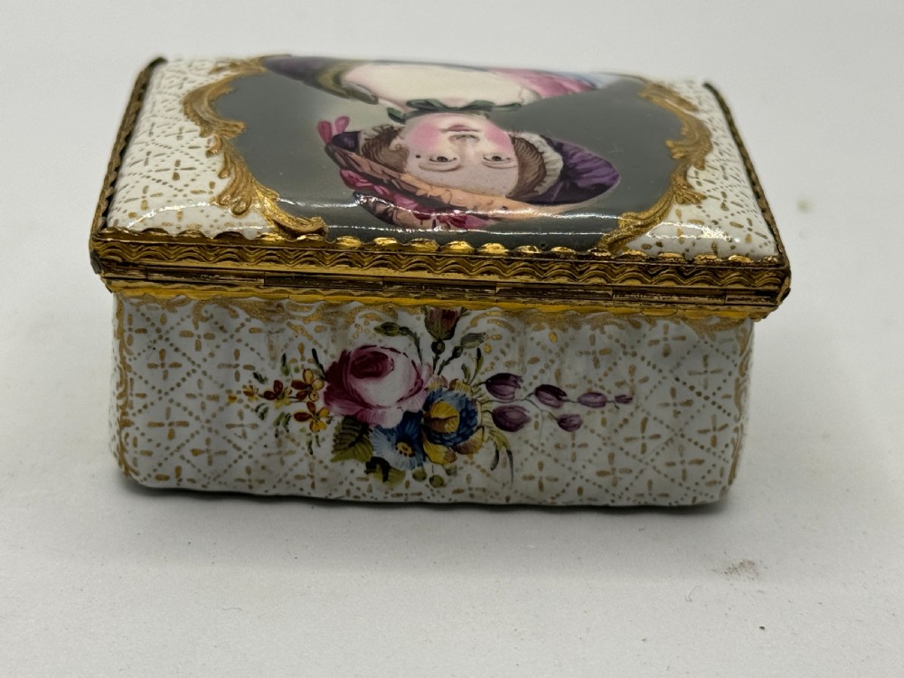 An 18th-century rectangular Bilston enamel box featuring a hand-painted portrait on the lid and floral motifs on white patterned sides. View V