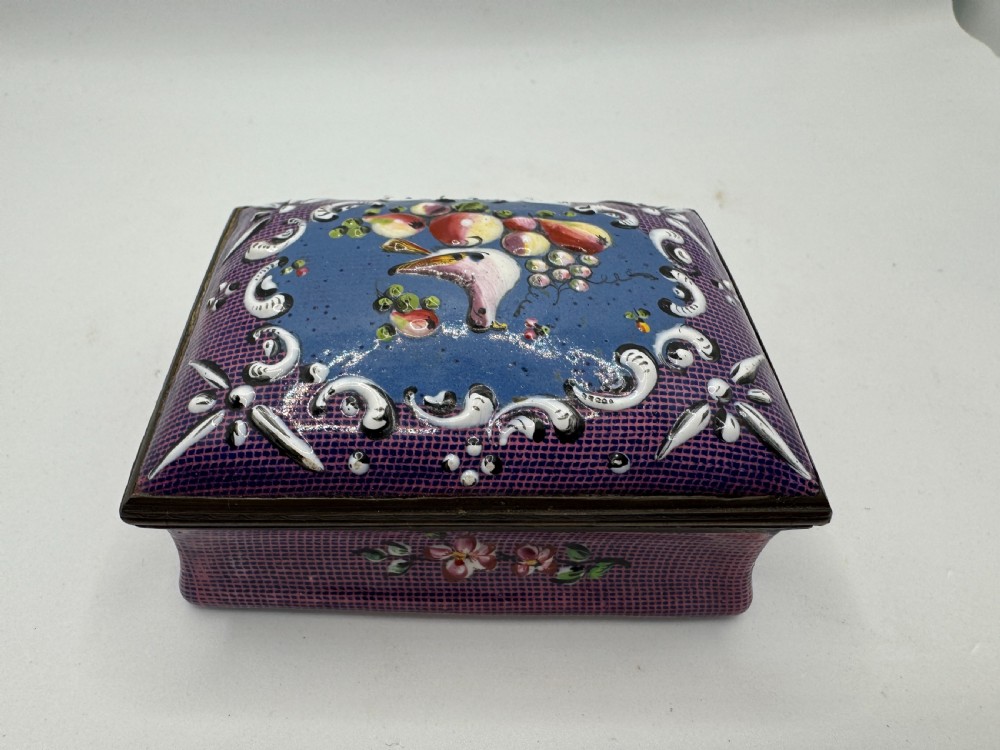 A rectangular eighteenth-century enamel box decorated with a central painted bird and fruit motif framed by white scrollwork against a purple lattice background. View III