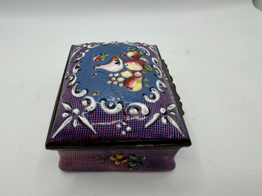 A rectangular eighteenth-century enamel box decorated with a central painted bird and fruit motif framed by white scrollwork against a purple lattice background. View IV
