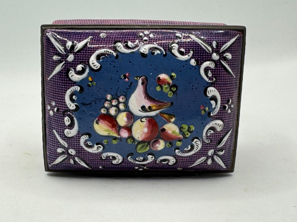 A rectangular eighteenth-century enamel box decorated with a central painted bird and fruit motif framed by white scrollwork against a purple lattice background. View X