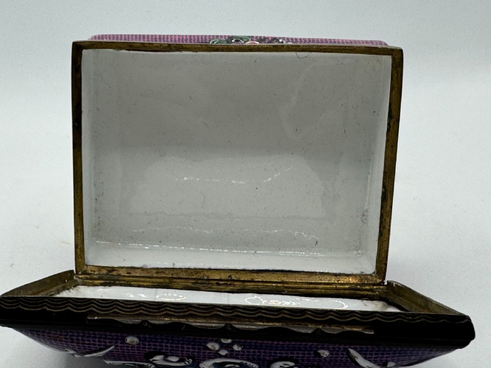 A rectangular eighteenth-century enamel box decorated with a central painted bird and fruit motif framed by white scrollwork against a purple lattice background. View XII