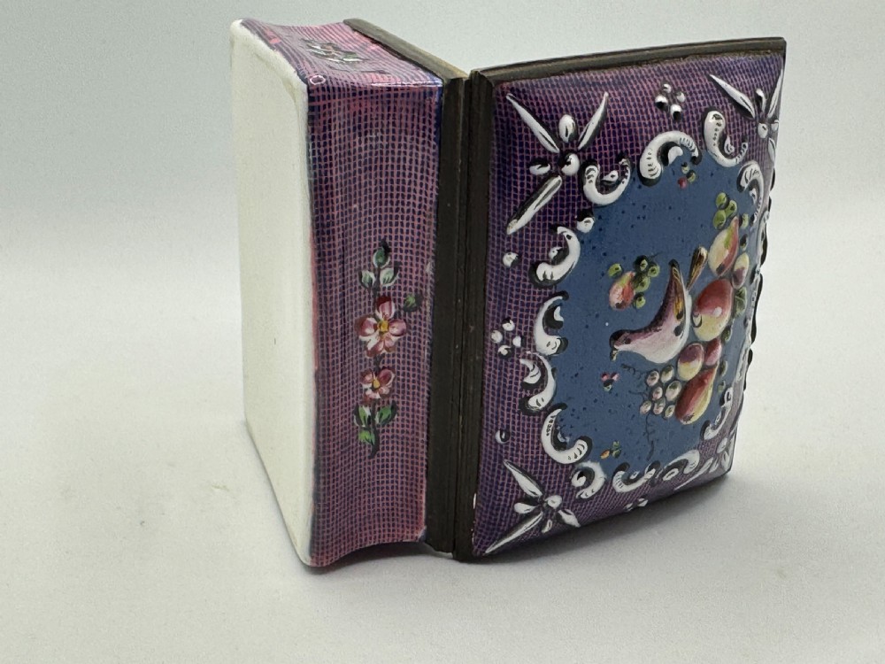 A rectangular eighteenth-century enamel box decorated with a central painted bird and fruit motif framed by white scrollwork against a purple lattice background. View XIV