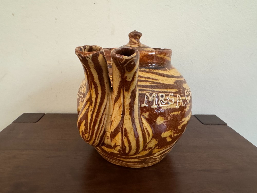 An Edwardian brown and cream marbled agateware teapot featuring twin spouts, a matching finial lid, and an inscribed date reading Todmorden Dec 1906. View III