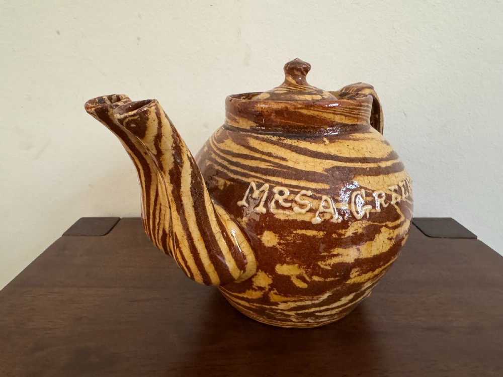 An Edwardian brown and cream marbled agateware teapot featuring twin spouts, a matching finial lid, and an inscribed date reading Todmorden Dec 1906. View V