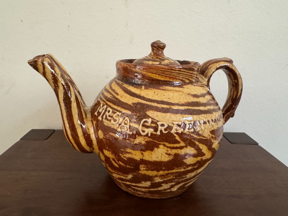An Edwardian brown and cream marbled agateware teapot featuring twin spouts, a matching finial lid, and an inscribed date reading Todmorden Dec 1906. View VI