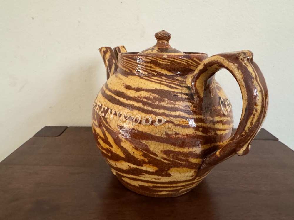 An Edwardian brown and cream marbled agateware teapot featuring twin spouts, a matching finial lid, and an inscribed date reading Todmorden Dec 1906. View VIII