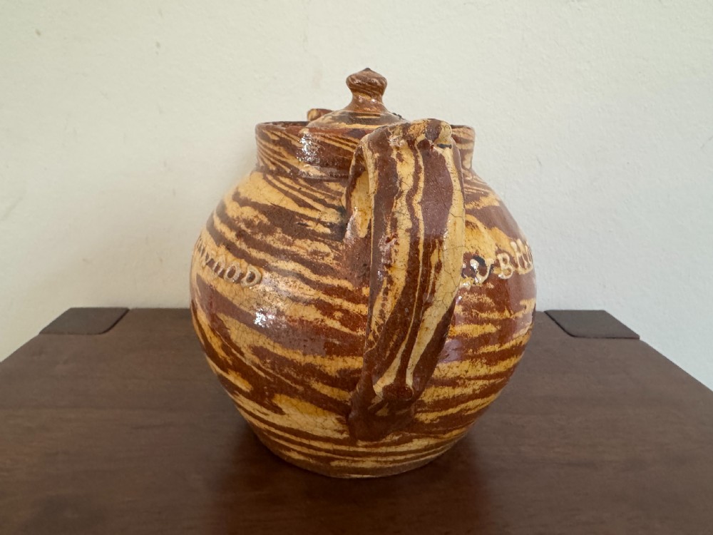 An Edwardian brown and cream marbled agateware teapot featuring twin spouts, a matching finial lid, and an inscribed date reading Todmorden Dec 1906. View IX