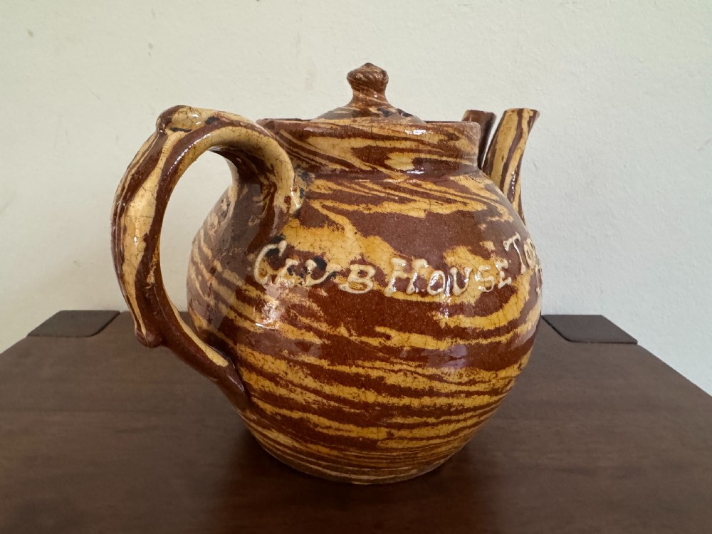 An Edwardian brown and cream marbled agateware teapot featuring twin spouts, a matching finial lid, and an inscribed date reading Todmorden Dec 1906. View X