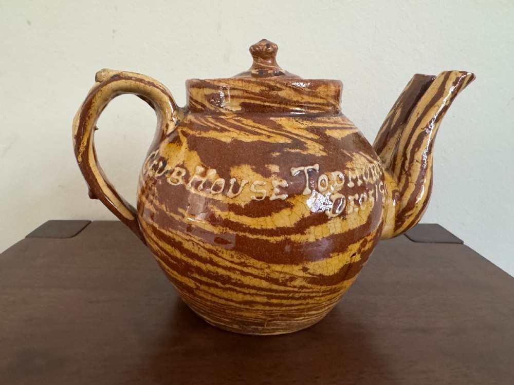 An Edwardian brown and cream marbled agateware teapot featuring twin spouts, a matching finial lid, and an inscribed date reading Todmorden Dec 1906. View XI