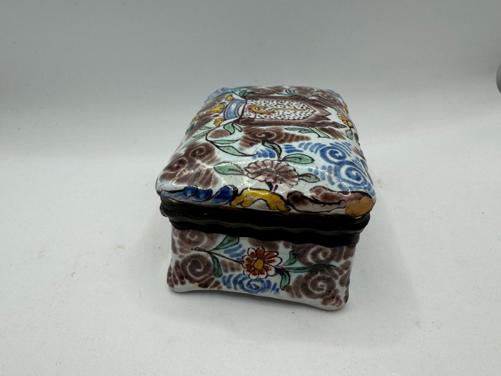 A small rectangular 17th-century Dutch Delft tin-glazed earthenware box featuring hand-painted polychrome floral motifs and an armorial shield crest. View III