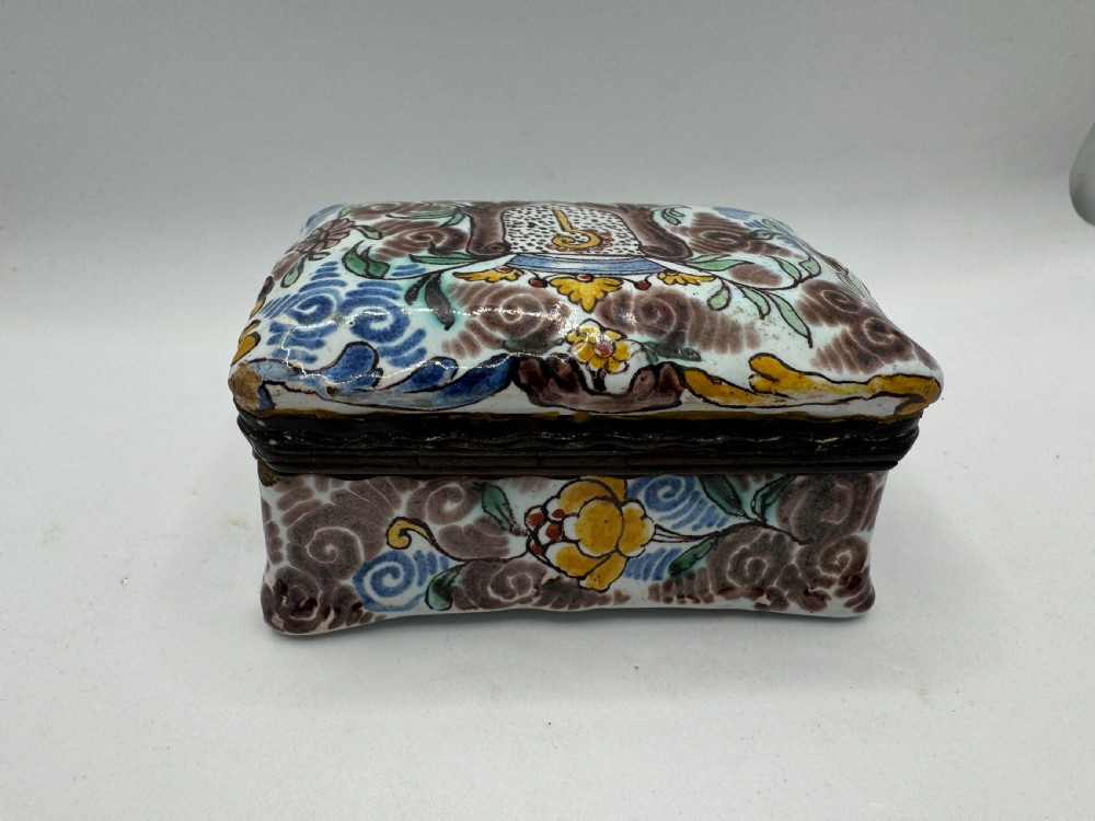 A small rectangular 17th-century Dutch Delft tin-glazed earthenware box featuring hand-painted polychrome floral motifs and an armorial shield crest. View VI