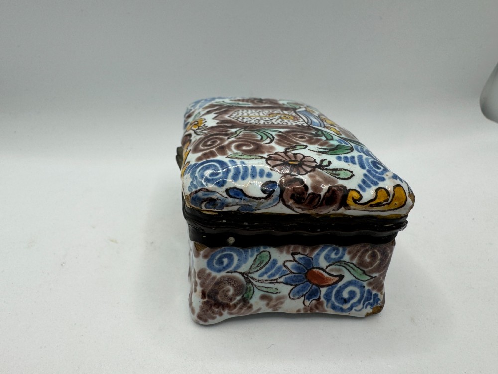 A small rectangular 17th-century Dutch Delft tin-glazed earthenware box featuring hand-painted polychrome floral motifs and an armorial shield crest. View VIII