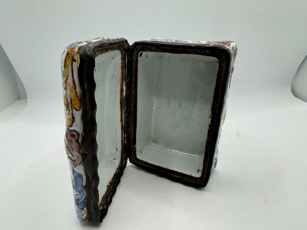 A small rectangular 17th-century Dutch Delft tin-glazed earthenware box featuring hand-painted polychrome floral motifs and an armorial shield crest. View XI