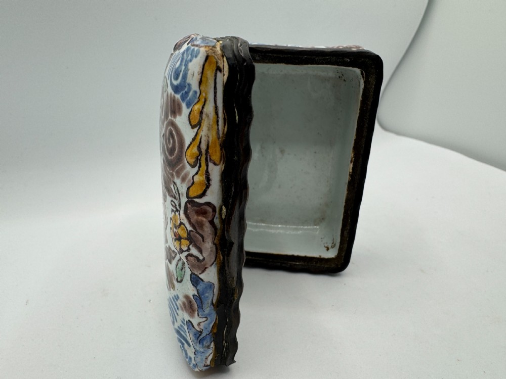 A small rectangular 17th-century Dutch Delft tin-glazed earthenware box featuring hand-painted polychrome floral motifs and an armorial shield crest. View XII