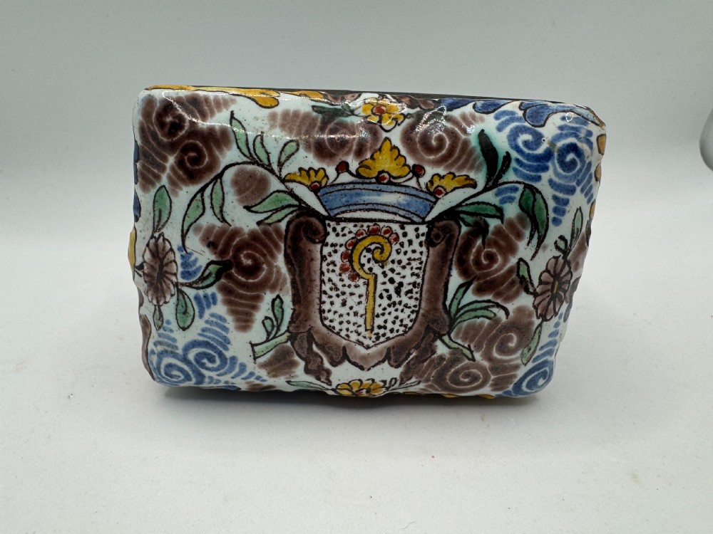 A small rectangular 17th-century Dutch Delft tin-glazed earthenware box featuring hand-painted polychrome floral motifs and an armorial shield crest. View XIII