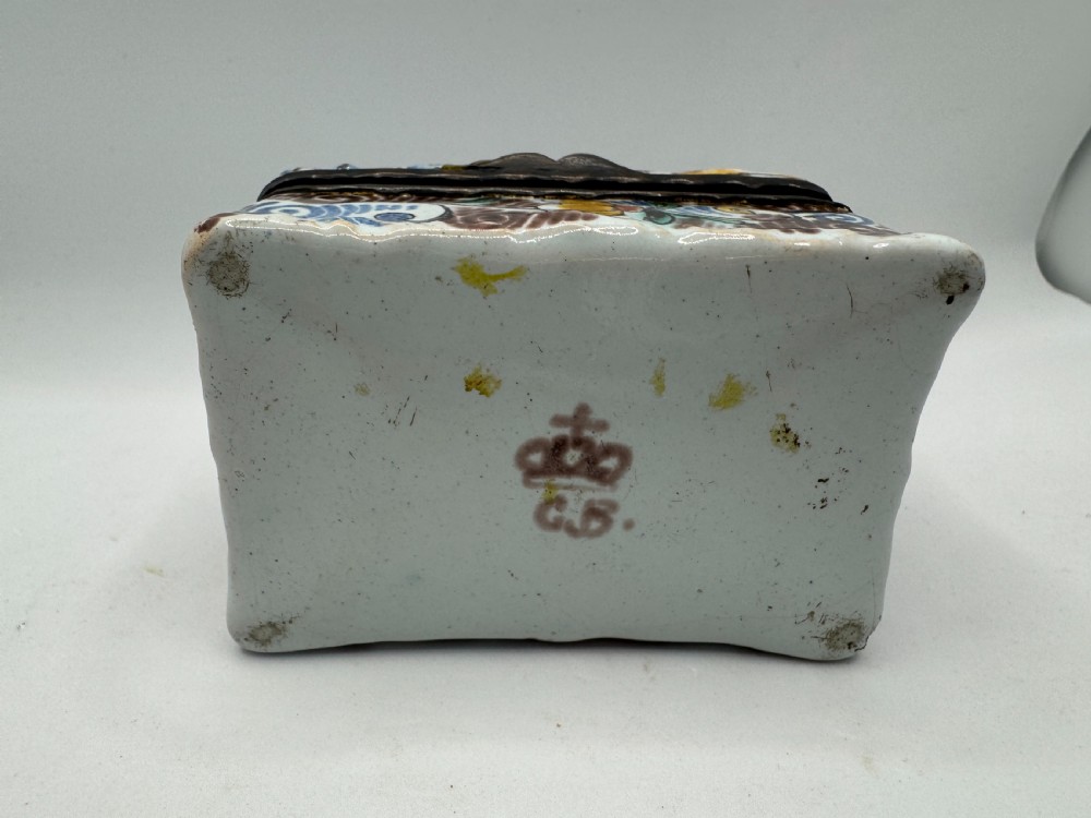 A small rectangular 17th-century Dutch Delft tin-glazed earthenware box featuring hand-painted polychrome floral motifs and an armorial shield crest. View XIV