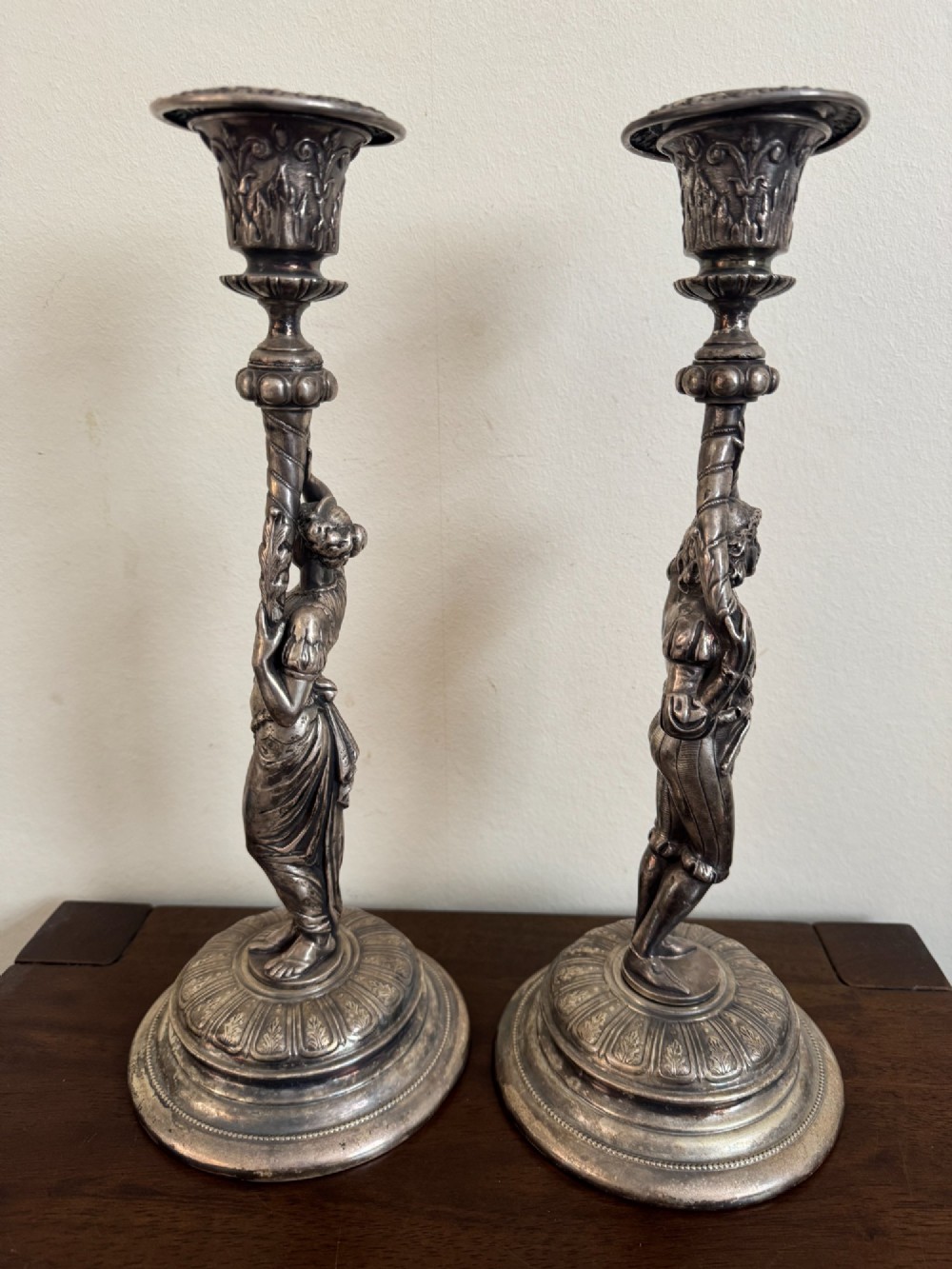 A pair of antique silver-plated candlesticks featuring detailed sculpted figures of a lady and a cavalier supporting sconces on rounded bases. View III
