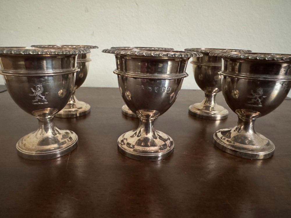 A Georgian sterling silver egg cruet stand holding six gilt-lined silver egg cups on a raised tray base with a central handle. View XI
