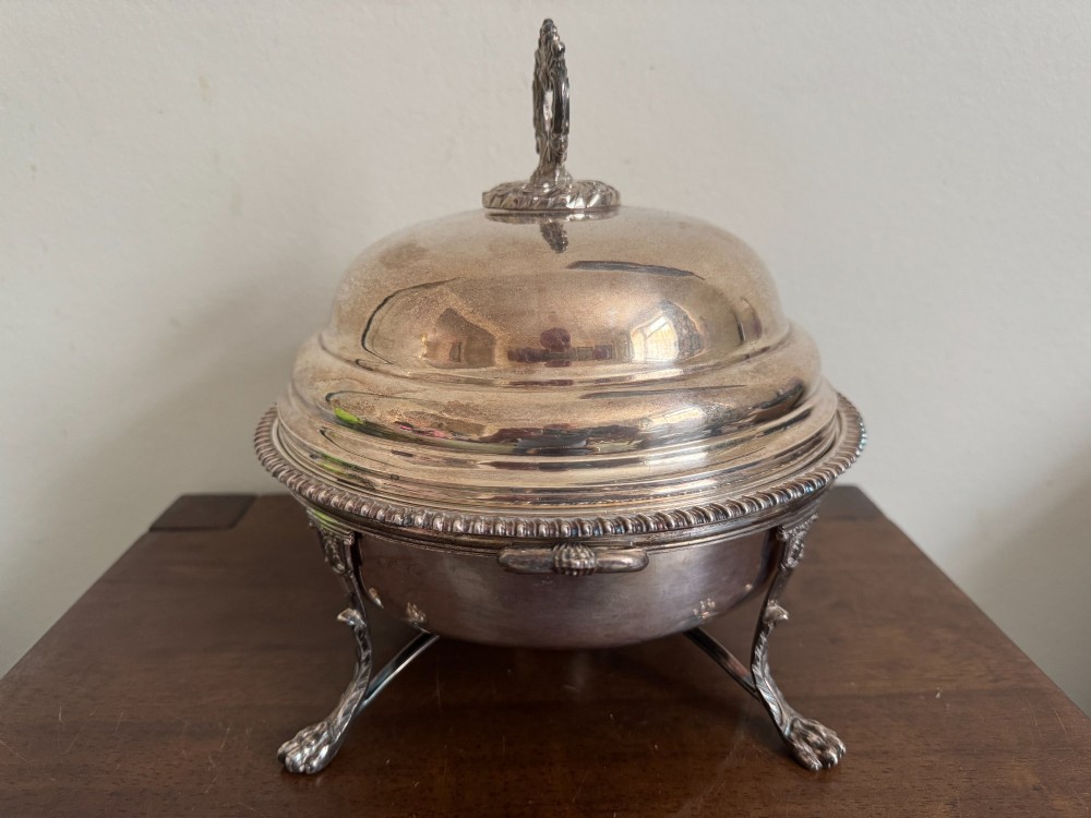A George III sterling silver domed supper dish featuring cast handles, gadrooned borders, and a matching stand supported by paw feet. View VII