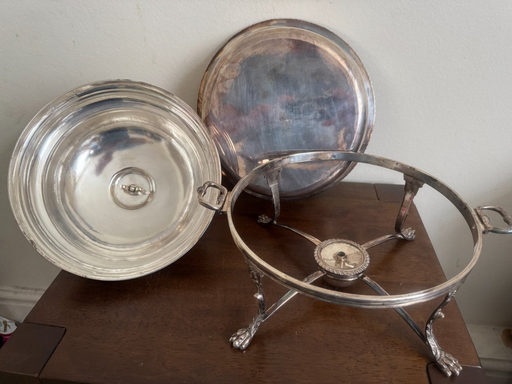 A George III sterling silver domed supper dish featuring cast handles, gadrooned borders, and a matching stand supported by paw feet. View XI