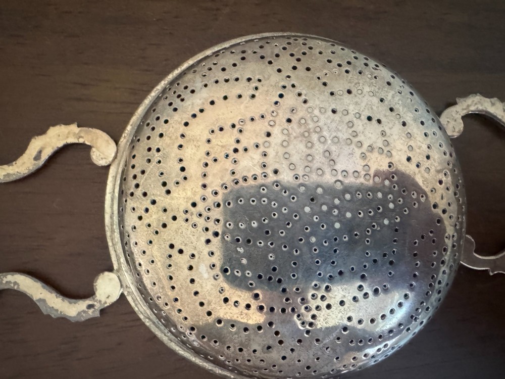 A matched pair of George III sterling silver lemon strainers featuring pierced geometric bowl patterns and dual side handles. View XIII