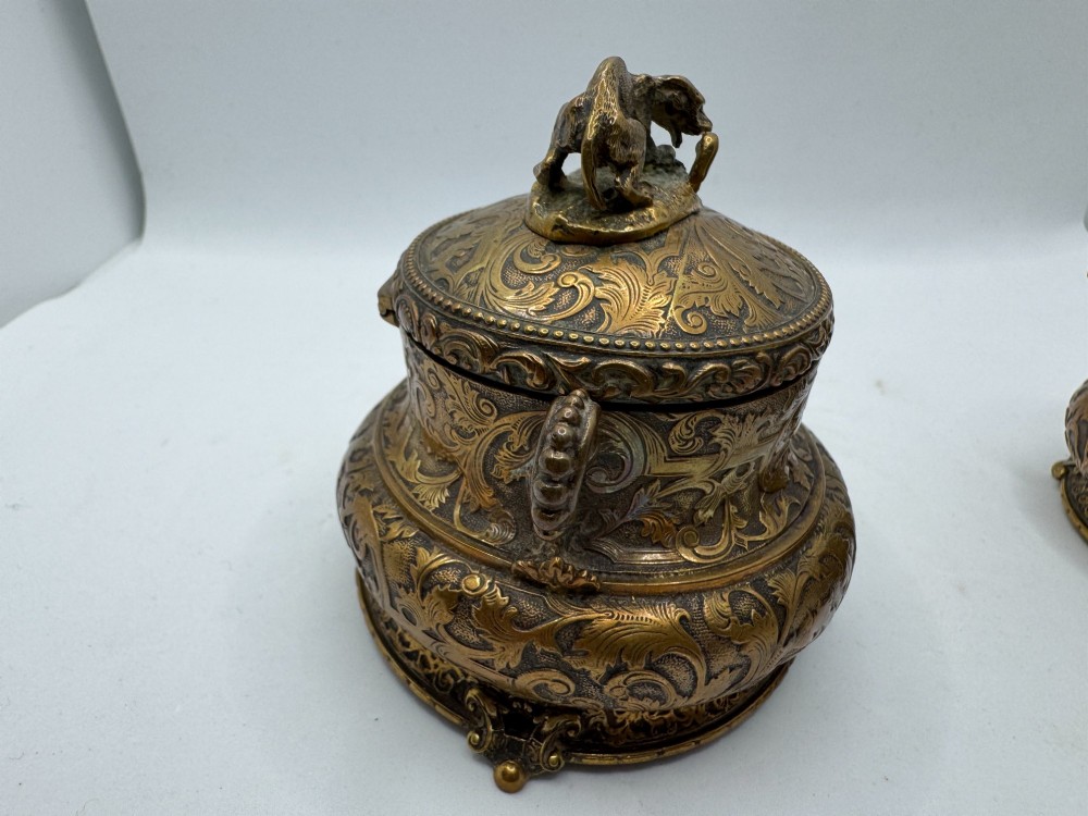 A pair of nineteenth-century gilt-metal jewellery caskets with acanthus leaf relief carving, side handles, and dog finials on the lids. View VI