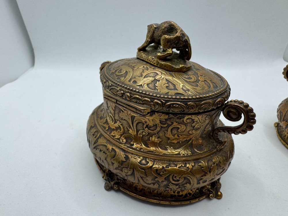A pair of nineteenth-century gilt-metal jewellery caskets with acanthus leaf relief carving, side handles, and dog finials on the lids. View VII