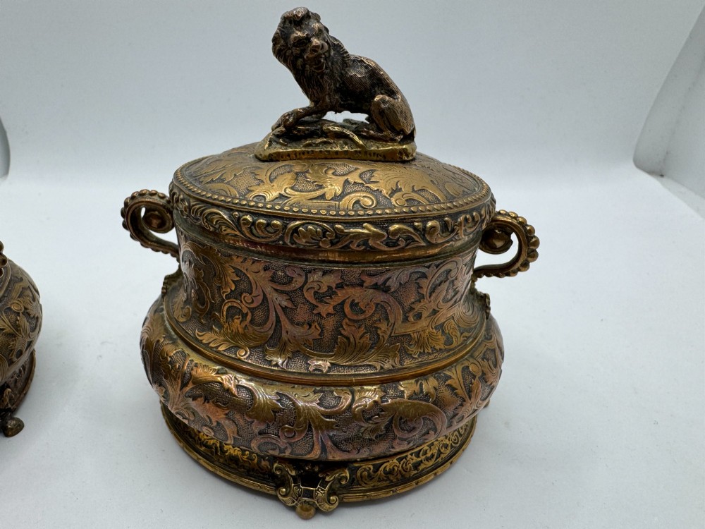 A pair of nineteenth-century gilt-metal jewellery caskets with acanthus leaf relief carving, side handles, and dog finials on the lids. View XI