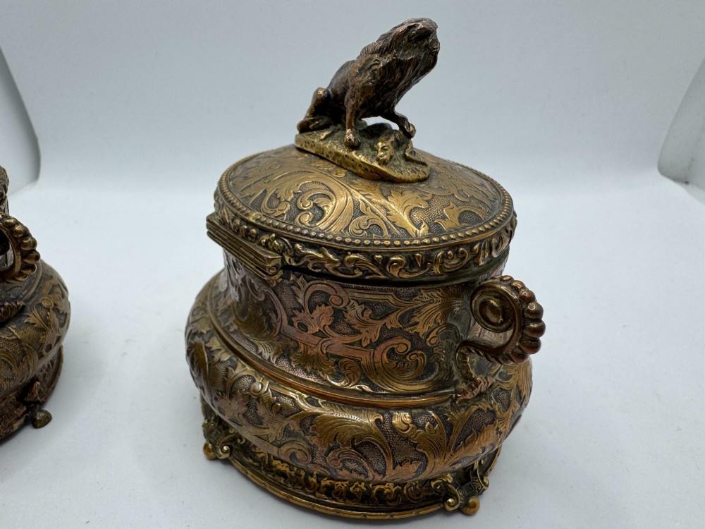 A pair of nineteenth-century gilt-metal jewellery caskets with acanthus leaf relief carving, side handles, and dog finials on the lids. View XV