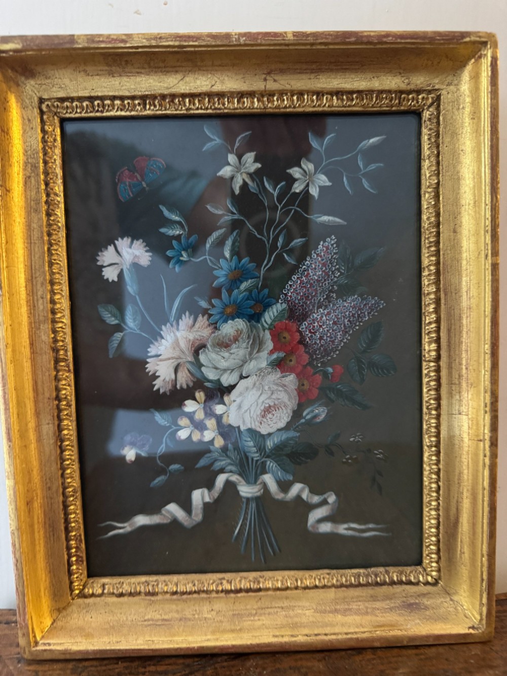 A pair of framed antique gouache paintings on dark backgrounds depicting floral bouquets tied with white ribbons, set in gilded frames. View VIII