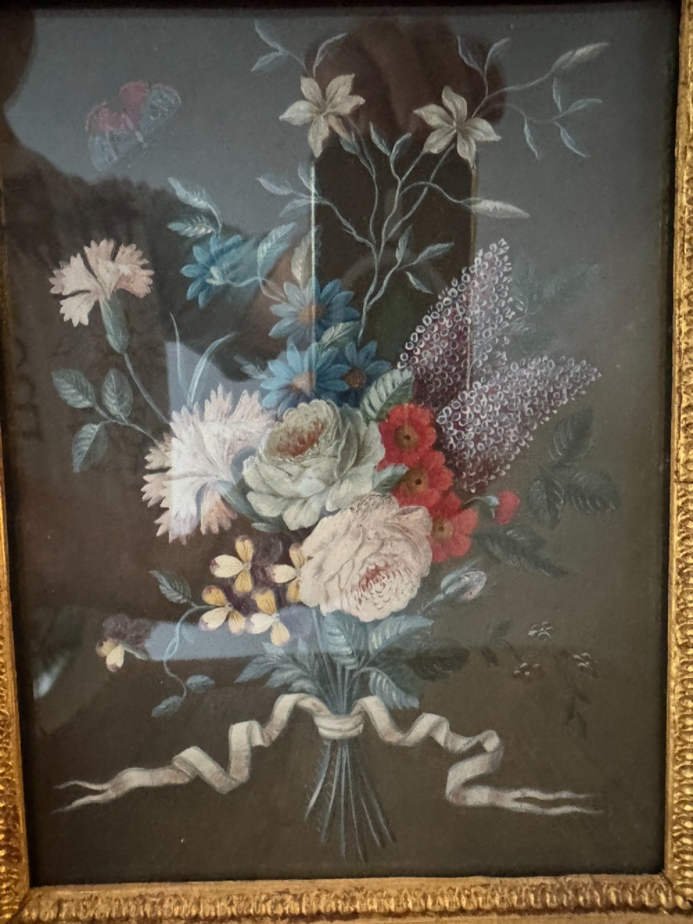 A pair of framed antique gouache paintings on dark backgrounds depicting floral bouquets tied with white ribbons, set in gilded frames. View IX