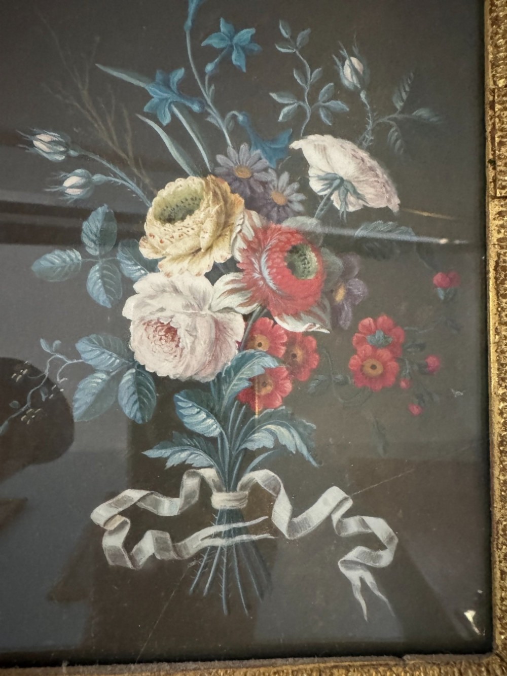 A pair of framed antique gouache paintings on dark backgrounds depicting floral bouquets tied with white ribbons, set in gilded frames. View VII