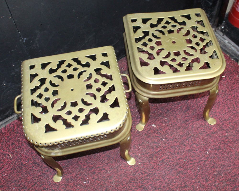A pair of early 19th-century brass footman trivets featuring pierced lattice tops, side handles, and cabriole legs. View III