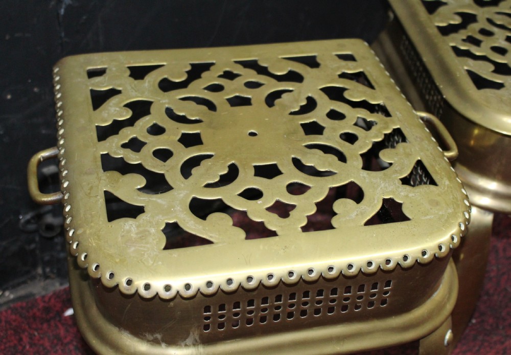 A pair of early 19th-century brass footman trivets featuring pierced lattice tops, side handles, and cabriole legs. View IV