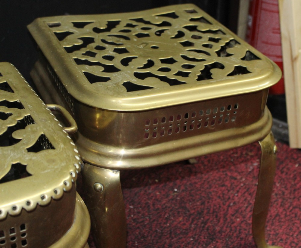 A pair of early 19th-century brass footman trivets featuring pierced lattice tops, side handles, and cabriole legs. View VII
