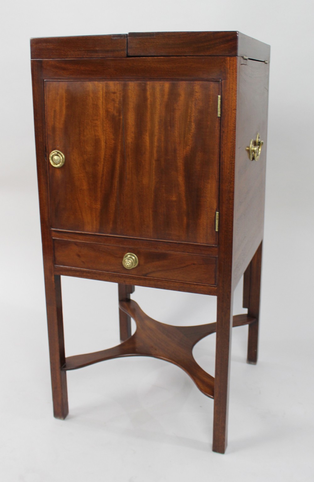 A George III mahogany vanity stand featuring a split folding top, a single cupboard door with a brass ring handle, a drawer, and an X-frame lower stretcher. View II