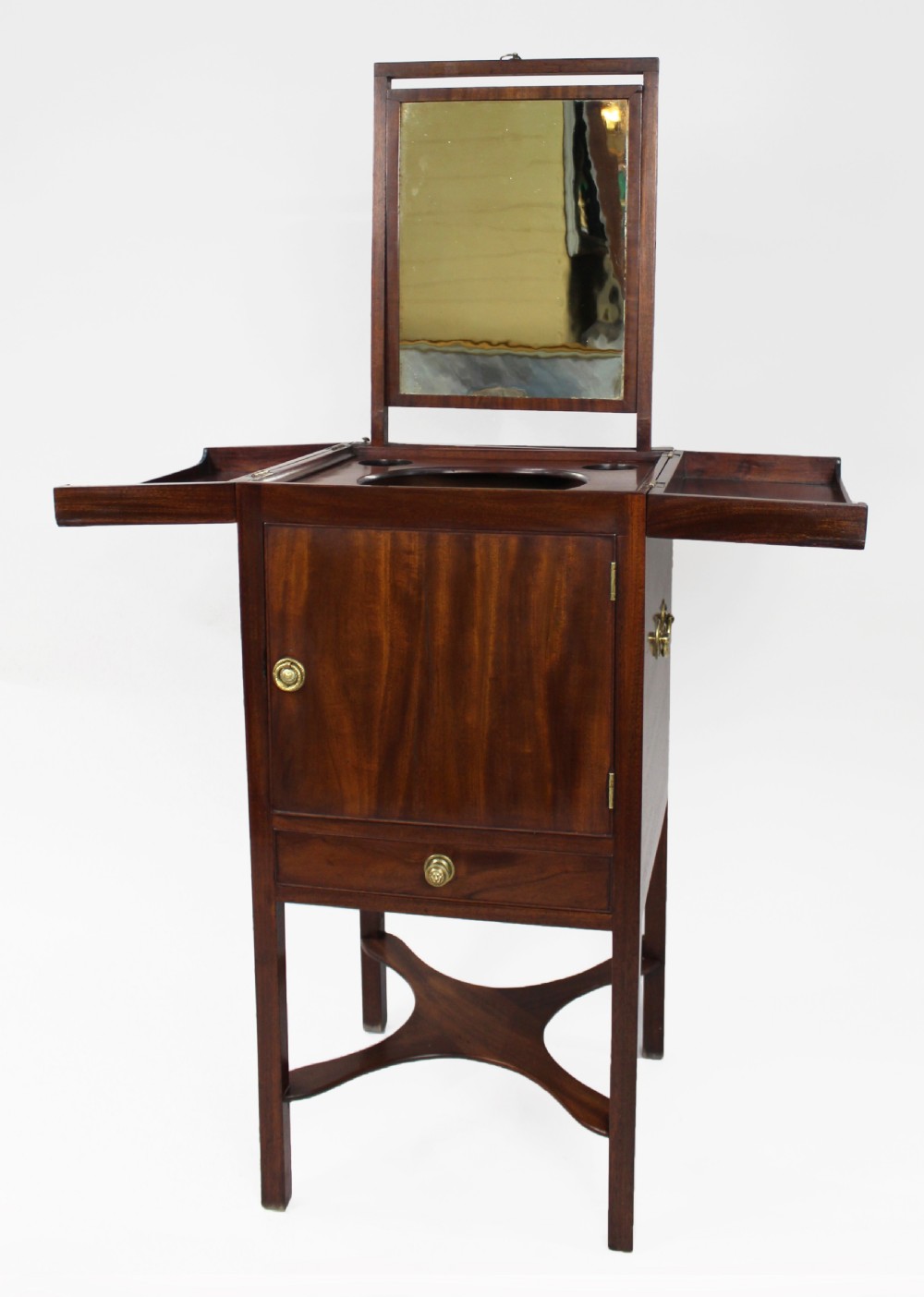 A George III mahogany vanity stand featuring a split folding top, a single cupboard door with a brass ring handle, a drawer, and an X-frame lower stretcher. View VI