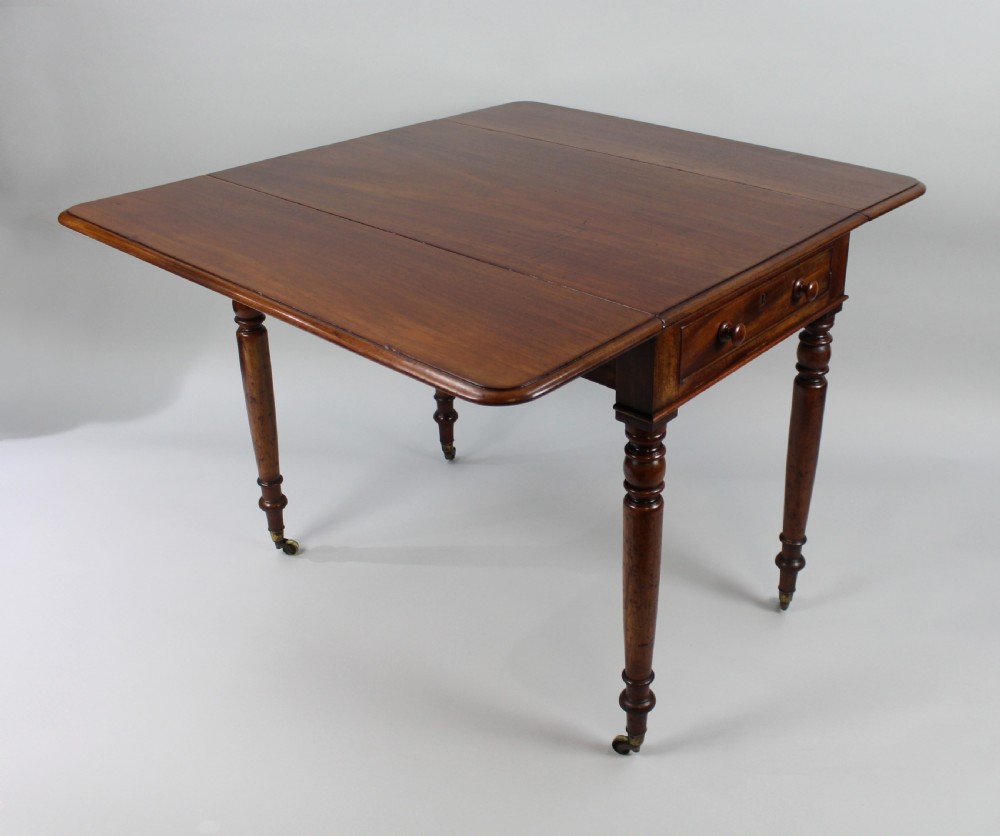 A Regency period mahogany Pembroke table featuring two drop leaves, a single end drawer with wooden turnings, four turned legs, and brass castors. View II