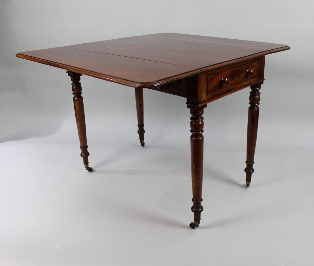 A Regency period mahogany Pembroke table featuring two drop leaves, a single end drawer with wooden turnings, four turned legs, and brass castors. View III