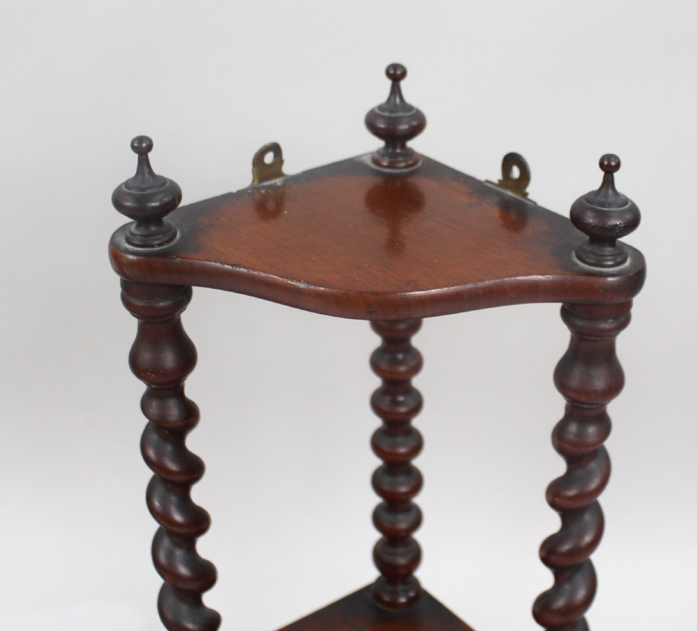 A pair of three-tiered dark mahogany corner shelves featuring barley twist turned pillars and top finials. View II