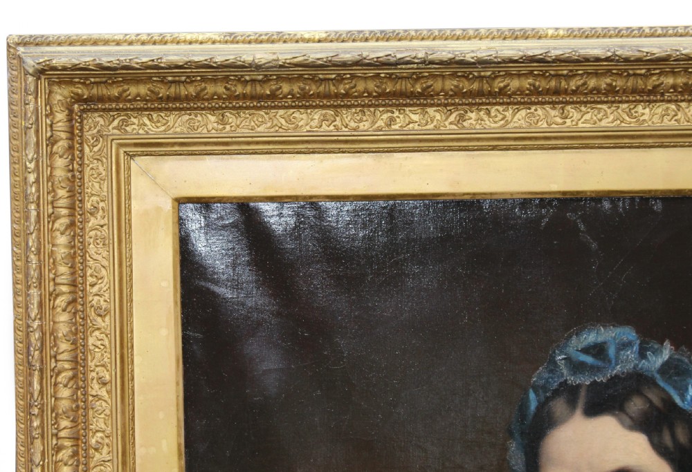 A mid-Victorian oil portrait of a seated lady wearing a black dress and blue lace bonnet inside a gilded wood frame. View V