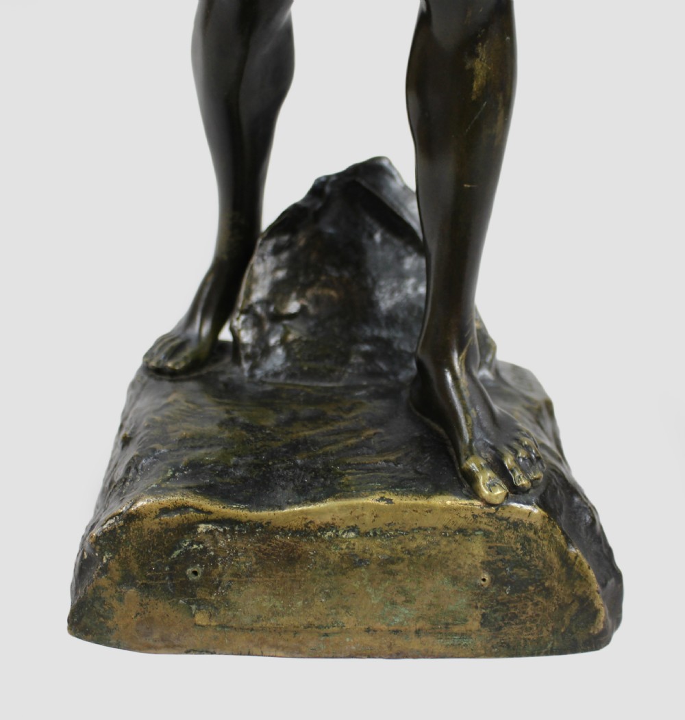 A dark patinated bronze sculpture depicting a standing classical male figure raising a laurel wreath in his right hand and holding a cup in his left hand. View XIV