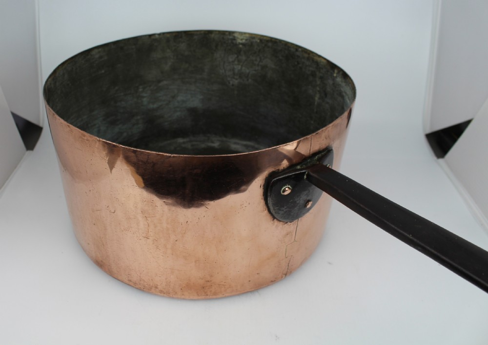 A large Georgian copper saucepan with a polished copper body, tin-lined interior, and a long black iron handle attached with rivets. View IV