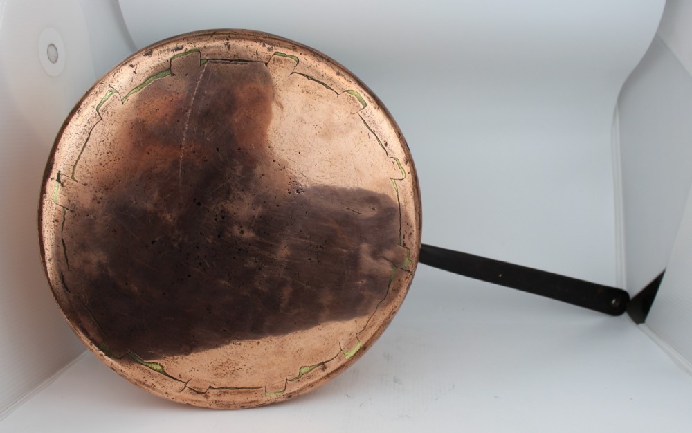 A large Georgian copper saucepan with a polished copper body, tin-lined interior, and a long black iron handle attached with rivets. View VI