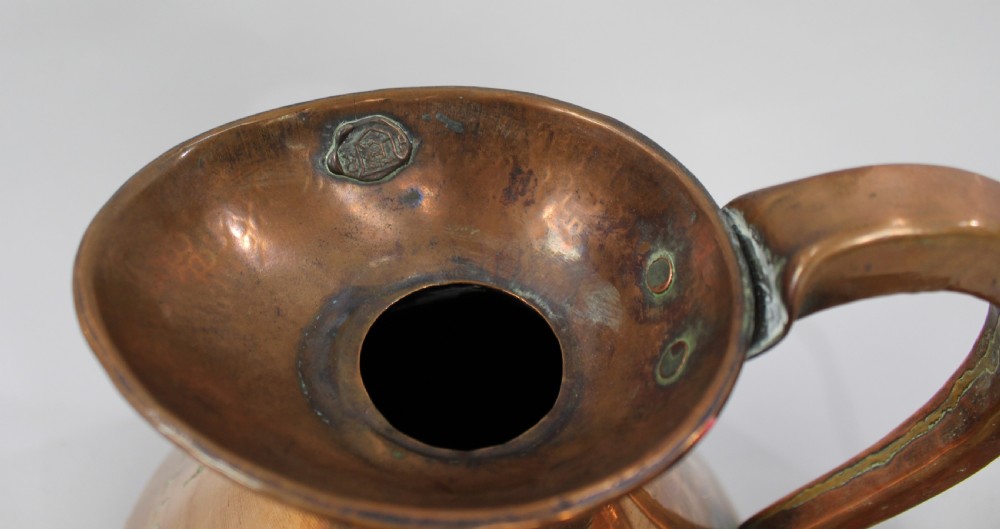 A set of six graduated antique copper haystack liquid measures ranging in size from one gallon down to one eighth gill, arranged on a plain background. View V