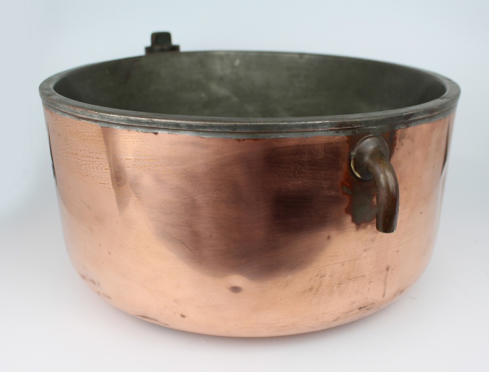 A large round antique copper bain marie pan featuring a dark tin-lined interior and side handles. View V